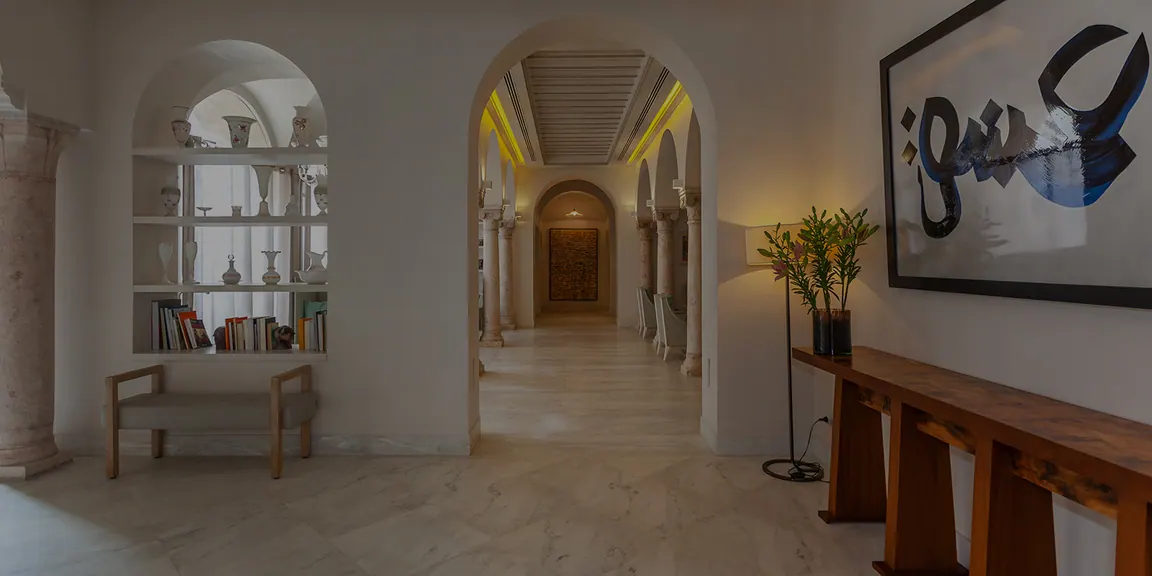 Hall de l'hôtel avec arcades blanches, bibliothèque et grande calligraphie murale