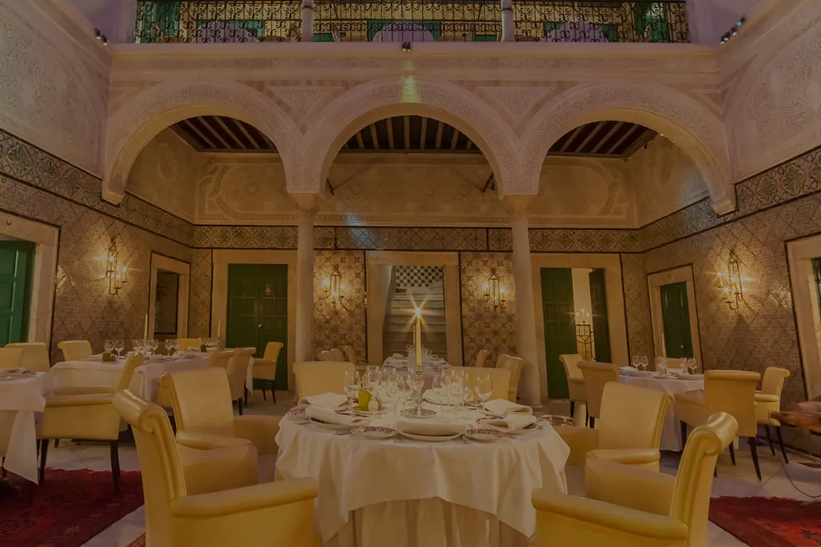 Patio du restaurant Dar El Jeld sous des arcades sculptées et faïences anciennes