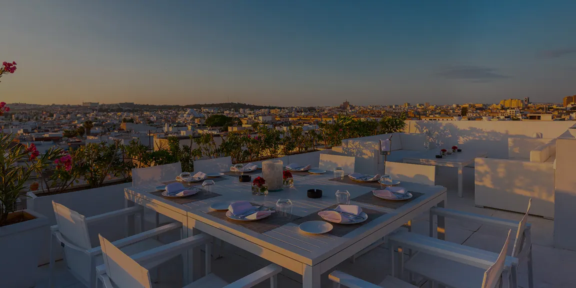 Table dressée sur le rooftop face à la médina au coucher du soleil
