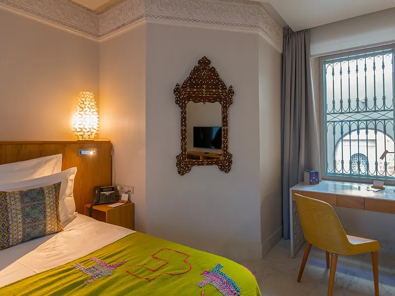 Luxury Suite bedroom with antique mirror, desk and wrought-iron window