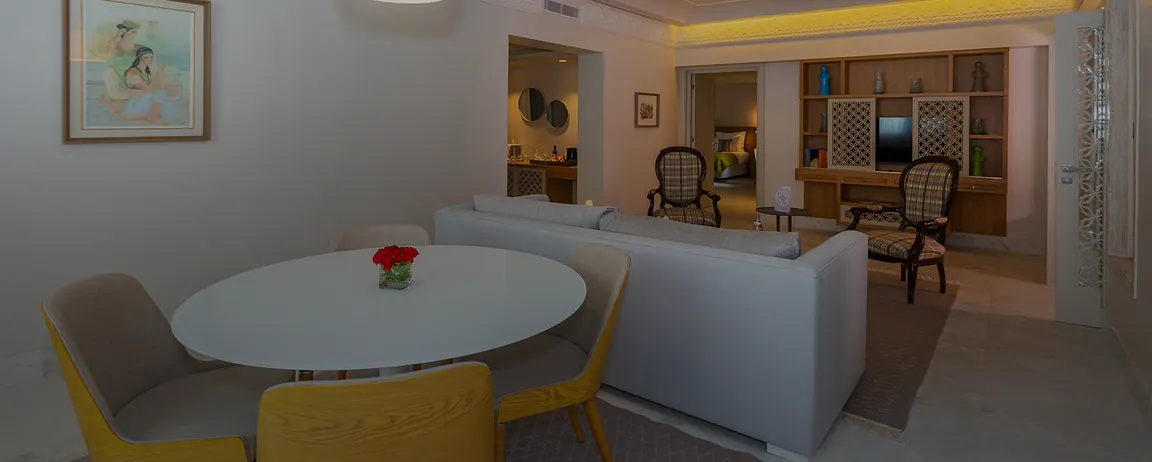 Suite Deluxe avec table ronde, chaises jaunes et grand canapé blanc