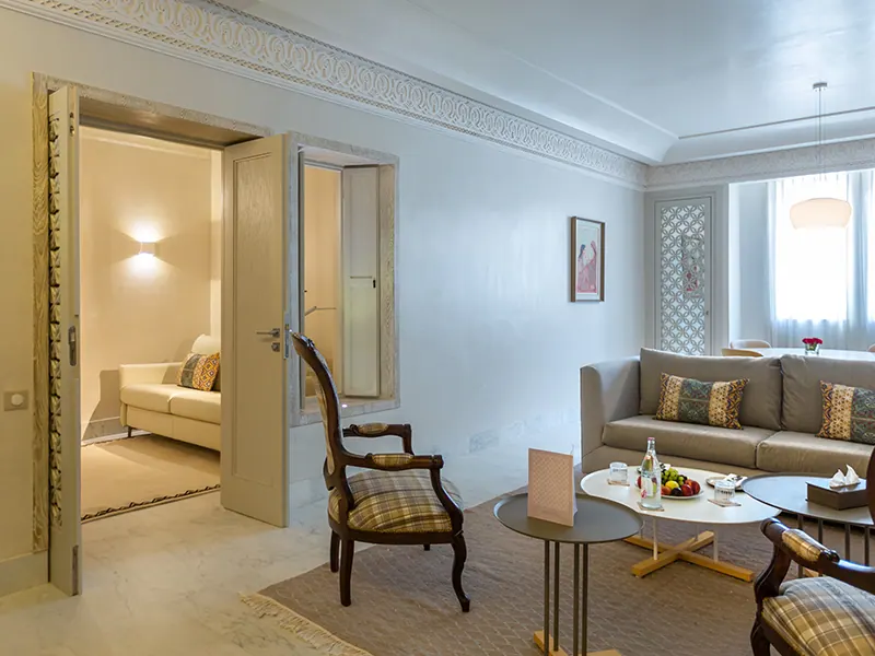 Luxury Suite living room with antique armchairs and separate bedroom
