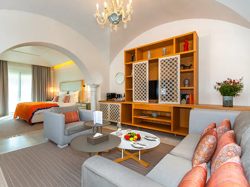 Overall view of the Junior Suite with lounge, chandelier and bed