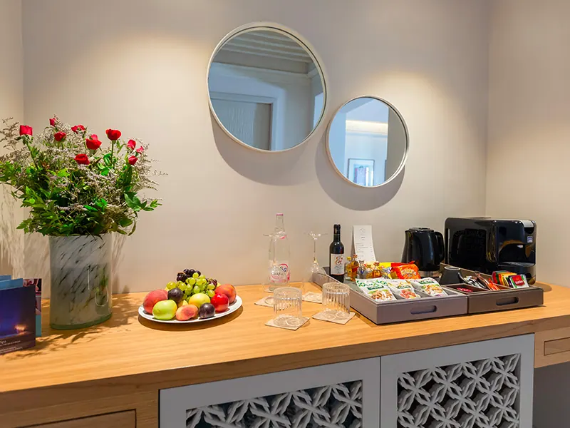 Coffee corner with Lavazza machine, fruit basket and red roses